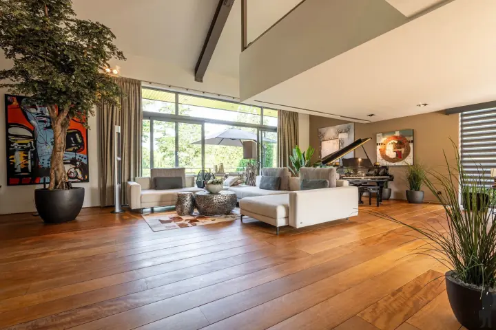 Zithoek in de woonkamer met vleugel en zicht op de tuin