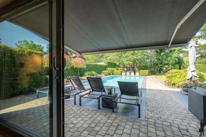 Zonneterras met ligbedden aan het zwembad