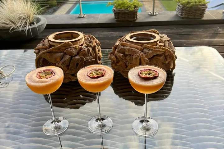 Cocktails op het terras met zicht op de tuin en het zwembad